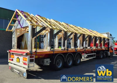 Dormers loaded and secured to a flat bed lorry ready for delivery on a bright day