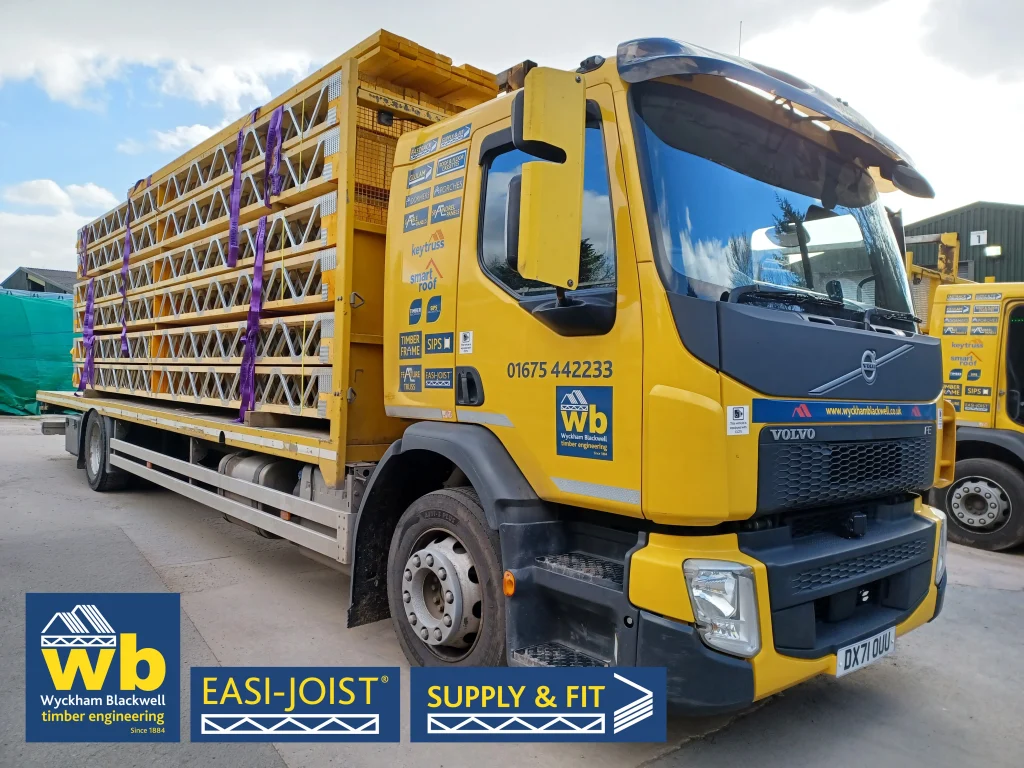 A front-angle of a yellow Wyckham Blackwell branded lorry with a full load of easi-joist metal web joists