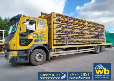 A yellow Wyckham Blackwell branded lorry with a full load of easi-joist metal web joists
