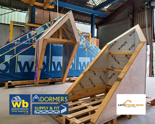 Two Wyckham Blackwell timber Dormer frames on pallets inside a workshop.