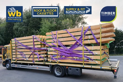 Wyckham Blackwell flatbed lorry carrying stacked prefabricated timber roof cassettes secured with purple straps for delivery.