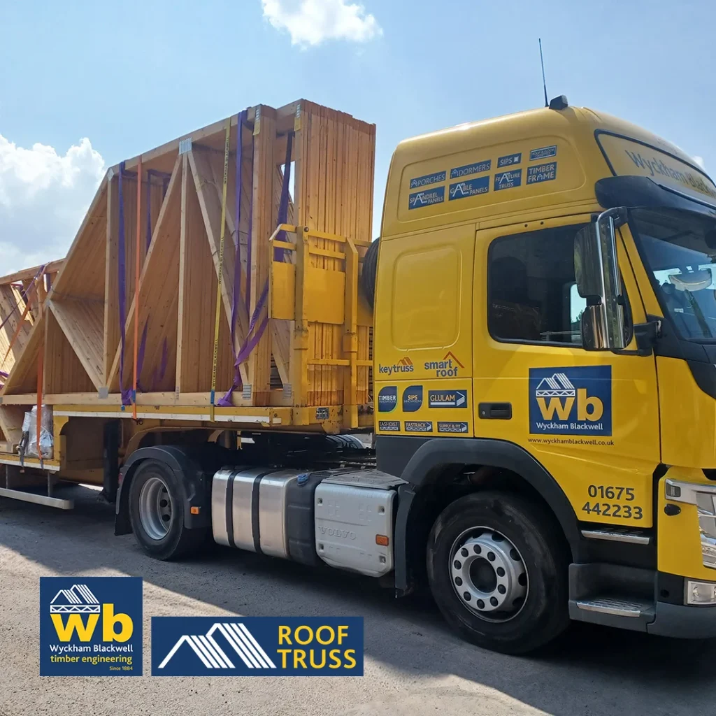 Yellow Wyckham Blackwell truck hauling wooden roof trusses on a flatbed trailer.