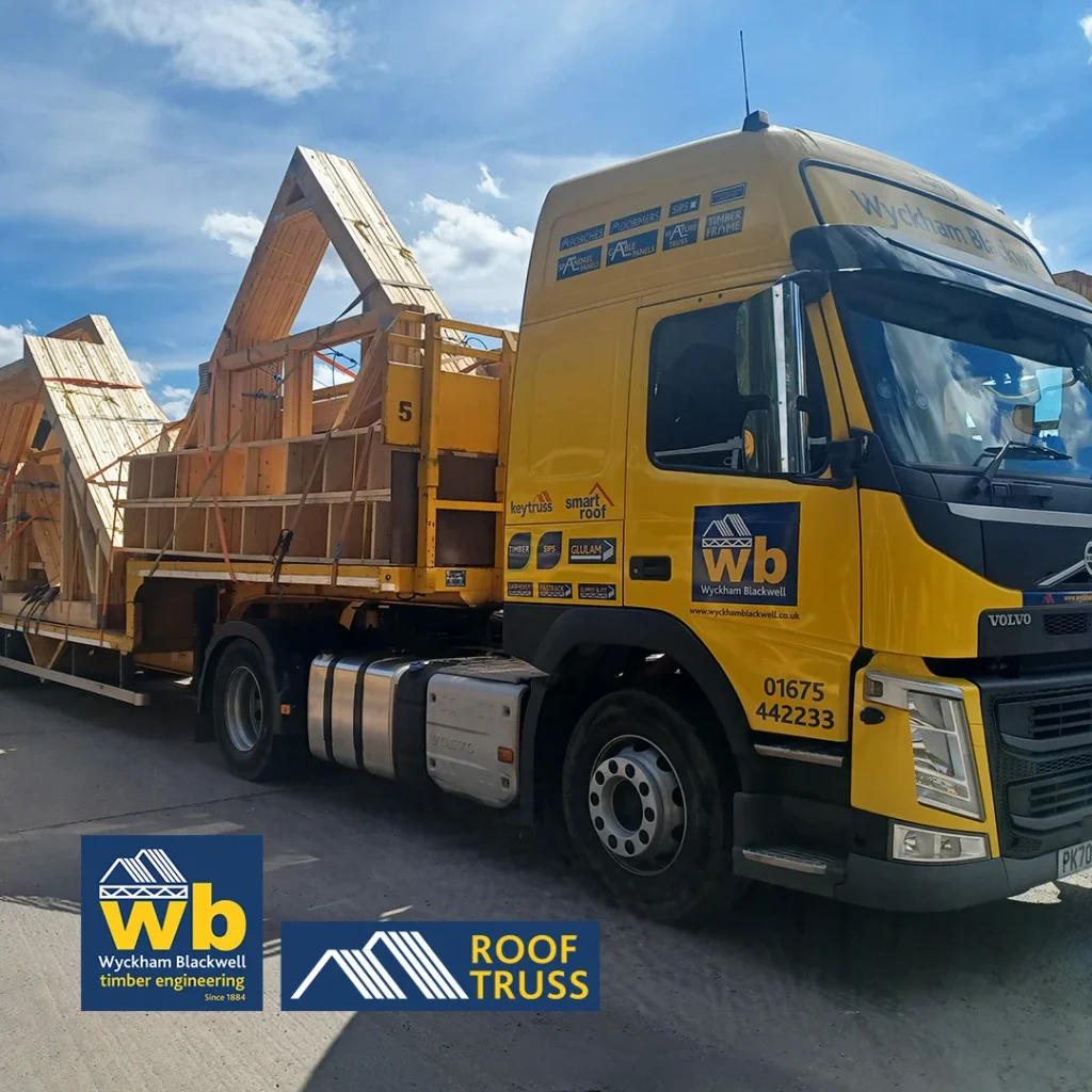 Yellow Wyckham Blackwell truck hauling wooden roof trusses on a flatbed trailer.