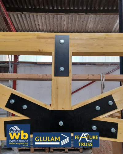 Glulam Feature Trusses joined with bolted black steel plates; Wyckham Blackwell company logo bottom left.