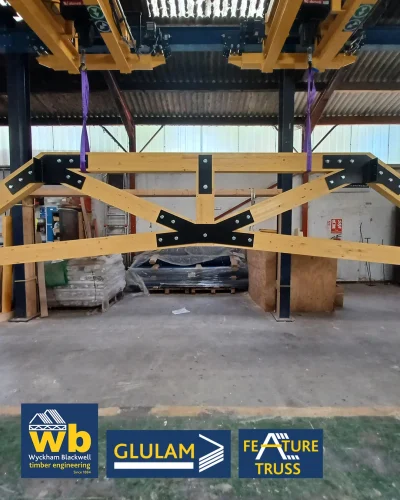 Glulam Feature Trusses joined with bolted black steel plates; Wyckham Blackwell company logo bottom left.