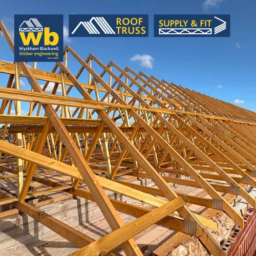 Rows of timber Roof Trusses on a building under a clear blue sky, Wyckham Blackwell logo in top left.