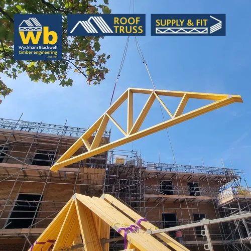 Timber Roof Truss lifted by crane above scaffolding at a construction site, with Wyckham Blackwell logo top left.