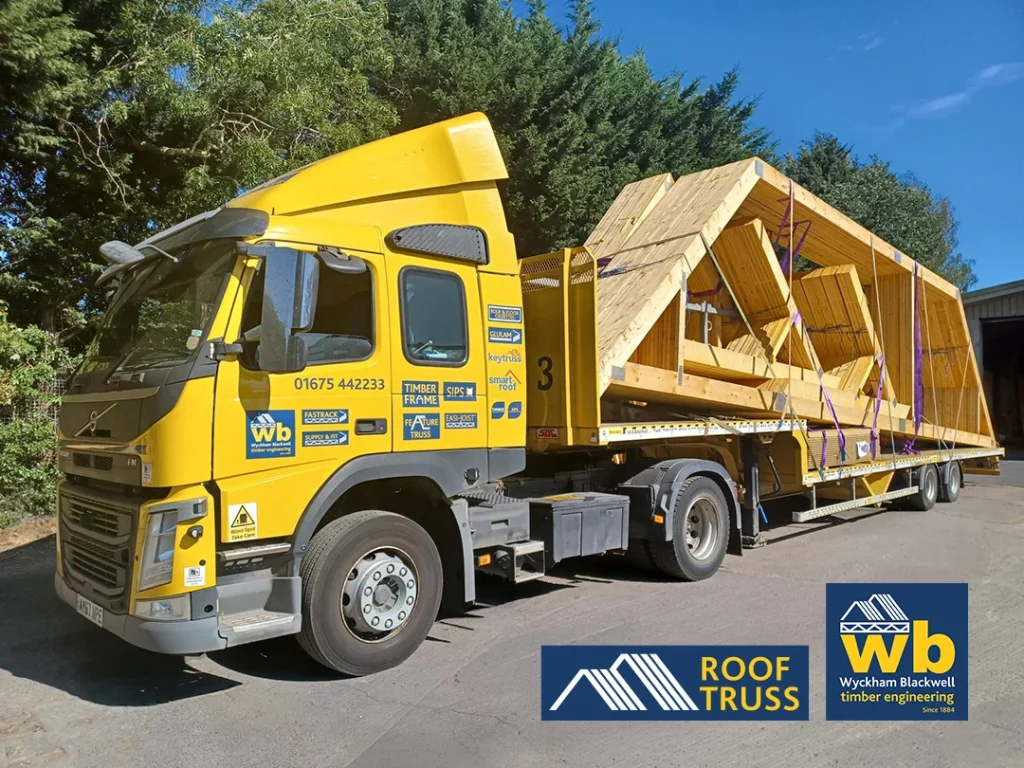 Yellow Wyckham Blackwell flatbed lorry with timber roof truss strapped on the back