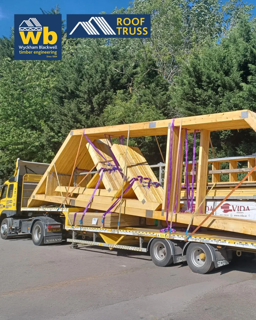 Yellow Wyckham Blackwell flatbed lorry with timber roof truss strapped on the back