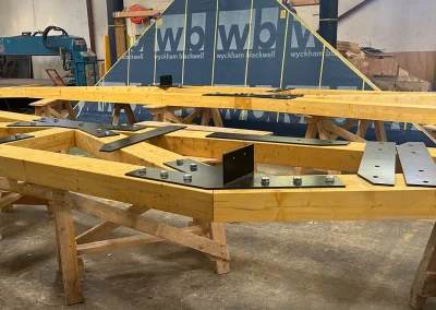 Glulam Feature Trusses joined with bolted black steel plates; Wyckham Blackwell company logo bottom left.