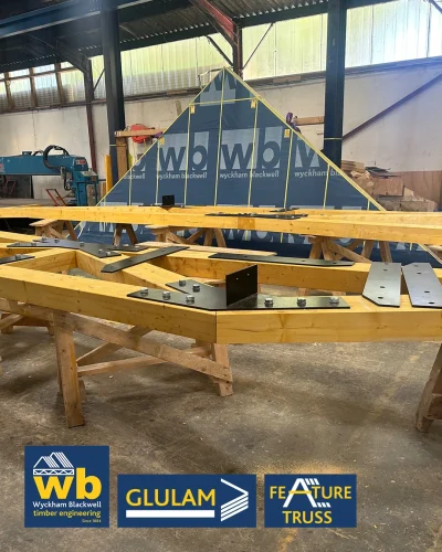 Glulam Feature Trusses joined with bolted black steel plates; Wyckham Blackwell company logo bottom left.